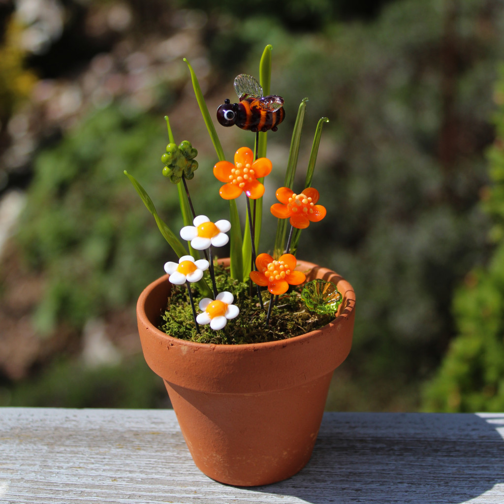 Biene mit orangen Blüten, Glücksklee und Gänseblümchen aus venezischem Glas, Muranoglas, im Tontopf mit Moos.
